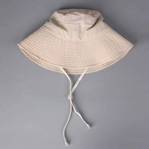 Close-up of beige sun hat with reinforced stitching and adjustable windproof cord