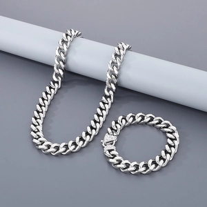 Polished silver men's curb chain necklace and bracelet set displayed on a blue stand