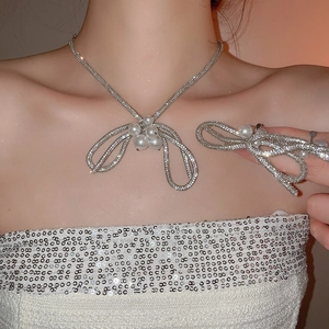 Close-up of elegant bow pendant necklace with sparkling rhinestones and pearl details
