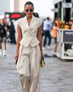 Detail of elegant beige sleeveless vest top and matching wide-leg trousers suit for women