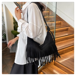 Détail du sac à bandoulière noir à franges en daim avec un design de style bohème