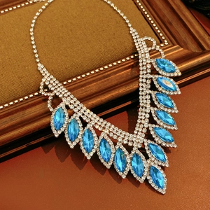 Macro detail of blue teardrop crystal necklace set with silver tassels and rhodium finish