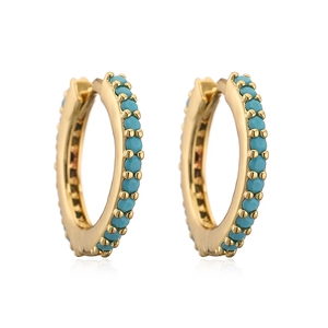 Detailed macro view of gold huggie earrings with sky blue turquoise inlay on white base
