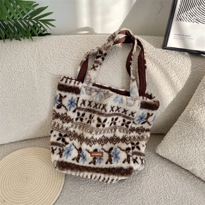 Detail of plush tote bag showing snowflake pattern and brown leather brand label