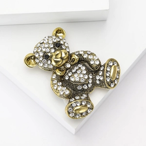 Sparkling crystal teddy bear brooch in vintage gold metal finish with heart detail