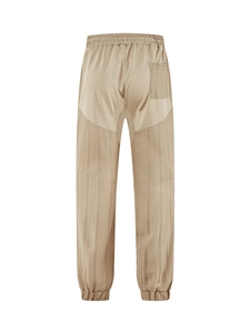 Detail view of khaki joggers featuring drawstring waist, back pocket and spliced fabric texture