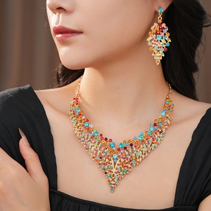 Detail shot of vintage golden leaf necklace and earrings set with colorful rhinestones