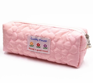Detail of quilted floral pencil case featuring a pearl zipper pull and pink fabric