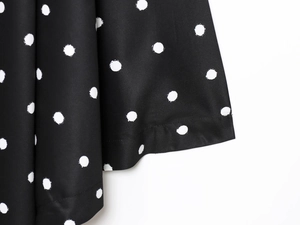 Detailed close-up of white polka dot pattern on black fabric showing smooth texture
