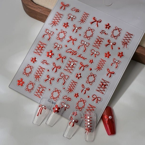 Detail of red bow and lace nail stickers model CG 376 on glossy acrylic nails