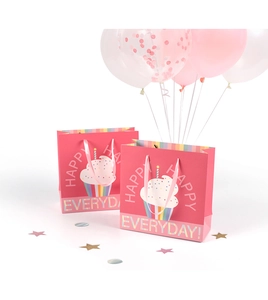 Detail of pink cartoon cupcake gift bag with happy everyday text and festive balloons