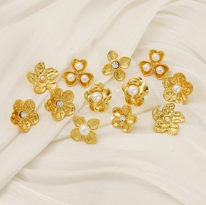 Detailed view of golden flower pearl earrings with intricate hammered metal textures