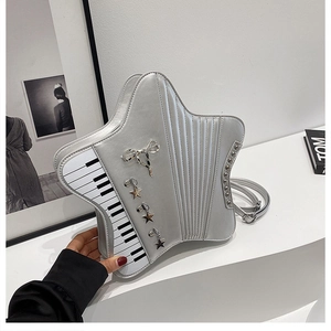 Close-up of star-shaped silver bag with piano key patterns and metal bow detail