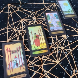 Detail of tarot cards Ace of Pentacles and Temperance on black celestial mat