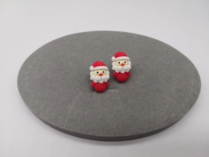 Detailansicht der Weihnachtsmann-Ohrstecker in Rot und Weiß auf grauem Samt