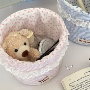 Pastel striped fabric storage basket with lace trim and polka dot lining for desk