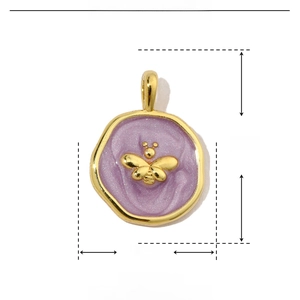 Detail view of gold bee pendant with purple enamel, measuring 18mm by 13mm in size