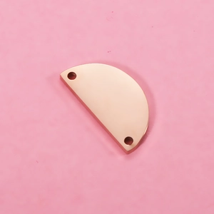 Macro shot of rose gold stainless steel semi-circle pendant with dual holes for DIY jewelry