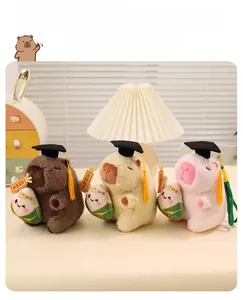 Close-up of three cute graduation capybara plush dolls in brown, beige, and pink colors