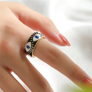 Detailed close-up of 18K gold-plated evil eye ring with colorful enamel inlay on a hand