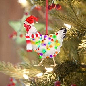 Detail of creative Christmas chicken ornament with red scarf and hat on a festive tree