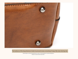 Detailed close-up of brown leather bag base showing durable metal wear-resistant rivets