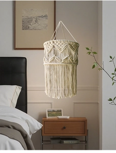 Detail of hand-woven bohemian lampshade with intricate diamond patterns and long cotton tassels