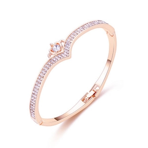 Close-up of rose gold V-shaped bracelet featuring a crown design and clear zircons