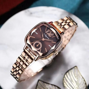 Détail de la montre carrée or rose avec strass sur un plateau en marbre