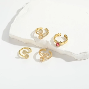 Set of four gold adjustable open rings featuring pink gemstone and shimmering crystals