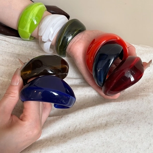 Detailed view of stackable colorful wide resin bracelets with polished mirror finish
