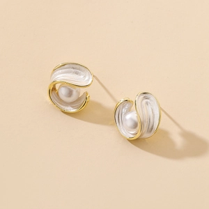 Detail of vintage geometric pearl earrings with gold shell design and white enamel finish