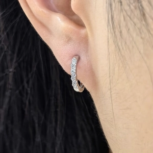 Close-up of S925 sterling silver huggie earrings with sparkling crystals on ear lobe