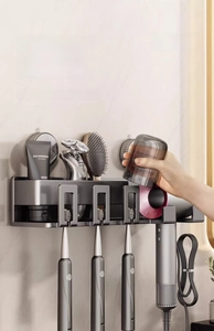 Detail of wall-mounted suction toothbrush and hair dryer rack in gunmetal finish