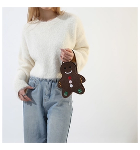 Détail du sac à main en feutre bonhomme de pain d'épices avec un pull blanc