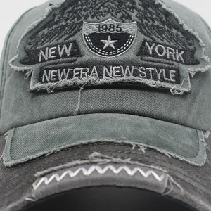 Macro detail of distressed washed grey cotton baseball cap with New York embroidery