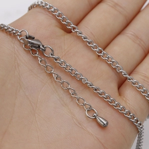 Close-up of a 3mm silver stainless steel curb chain with clasp and extension on a hand