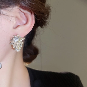 Close-up of elegant leaf diamond stud earrings on model showing cubic zirconia sparkle