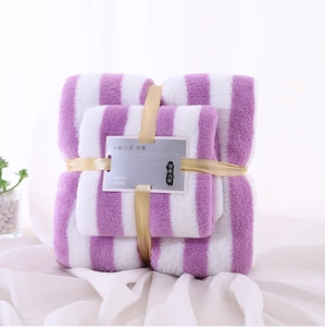 Detail of purple striped coral fleece towel set with decorative gold ribbon and tag