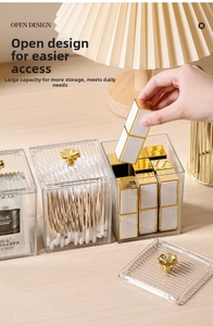 Close-up of acrylic storage box with a golden clover handle on a wooden table