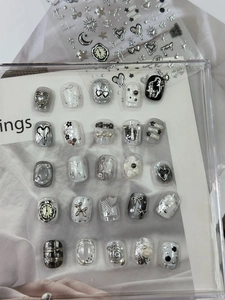 Macro detail of 3D metallic silver Y2K nail art stickers and finished press-on nails