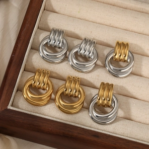 Three pairs of vintage multi-layer twisted metal hoop earrings in gold and silver finishes