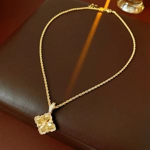 Macro d'un pendentif trèfle doré serti de zircons brillants sur une surface en cuir