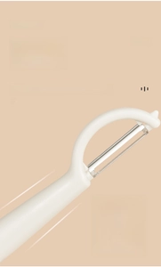 Close-up of multifunctional peeler with ergonomic curved handle and sharp steel blade