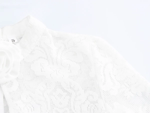 Close-up of white lace dress featuring high neck collar and fabric rose decoration