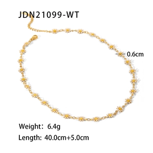 Detalle de dijes de margaritas blancas en una cadena de acero de titanio dorado de 40cm