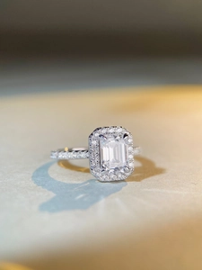 Detailed macro view of S925 silver halo ring with an emerald-cut centerpiece gemstone