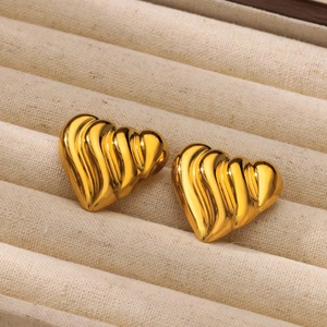 Textured 18K gold stainless steel heart stud earrings on a beige jewelry display