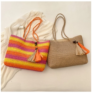Flat lay of colorful rainbow striped and khaki straw tote bags with decorative tassels