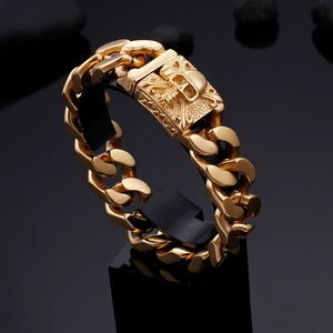 Macro shot of gold stainless steel Cuban chain bracelet with skull crossbone detail